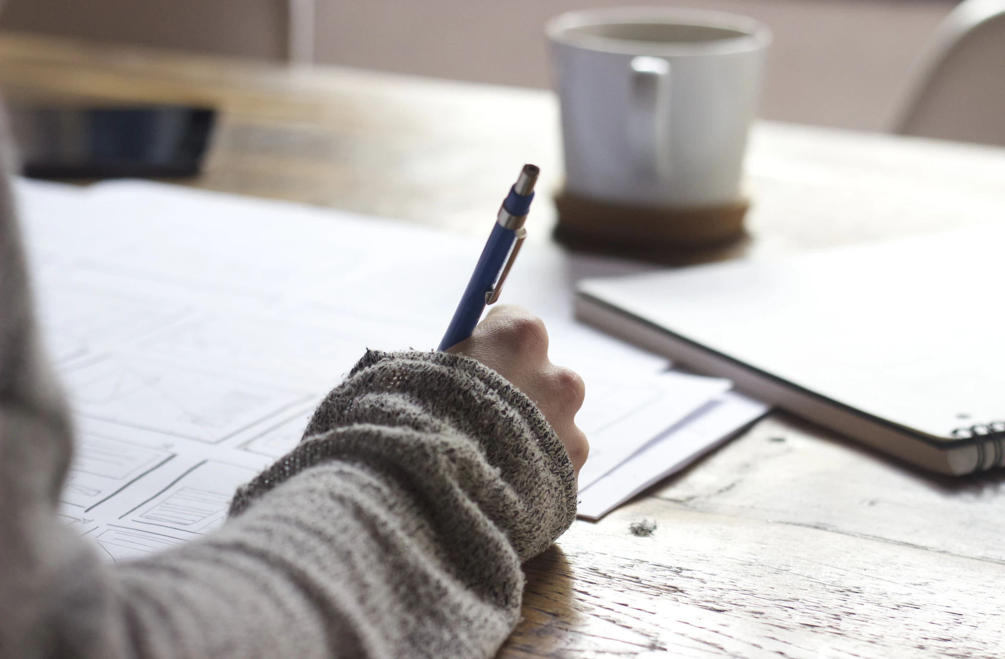 Person writing an audit checklist at a desk