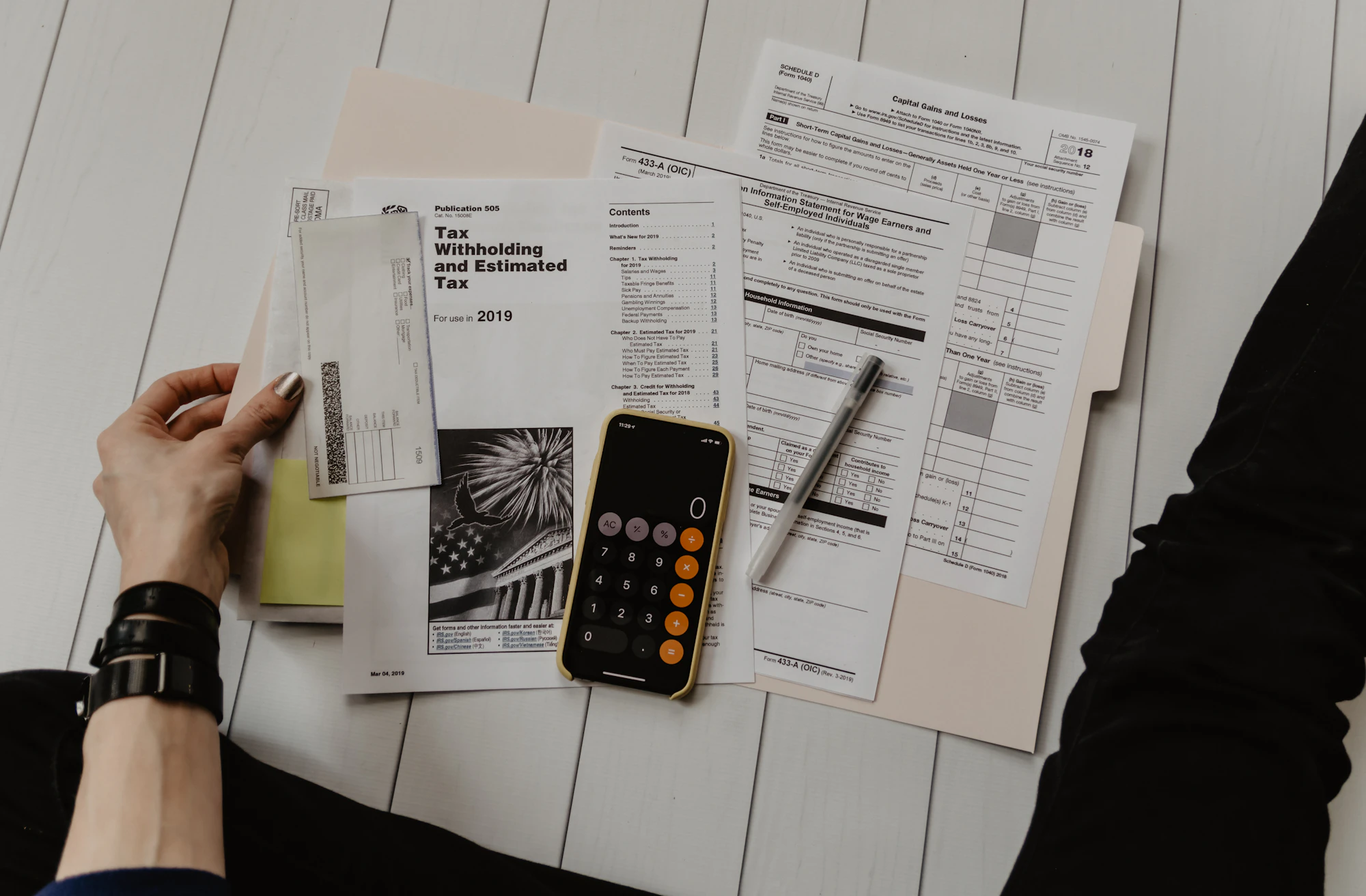Paper records and a calculator spread across a desk