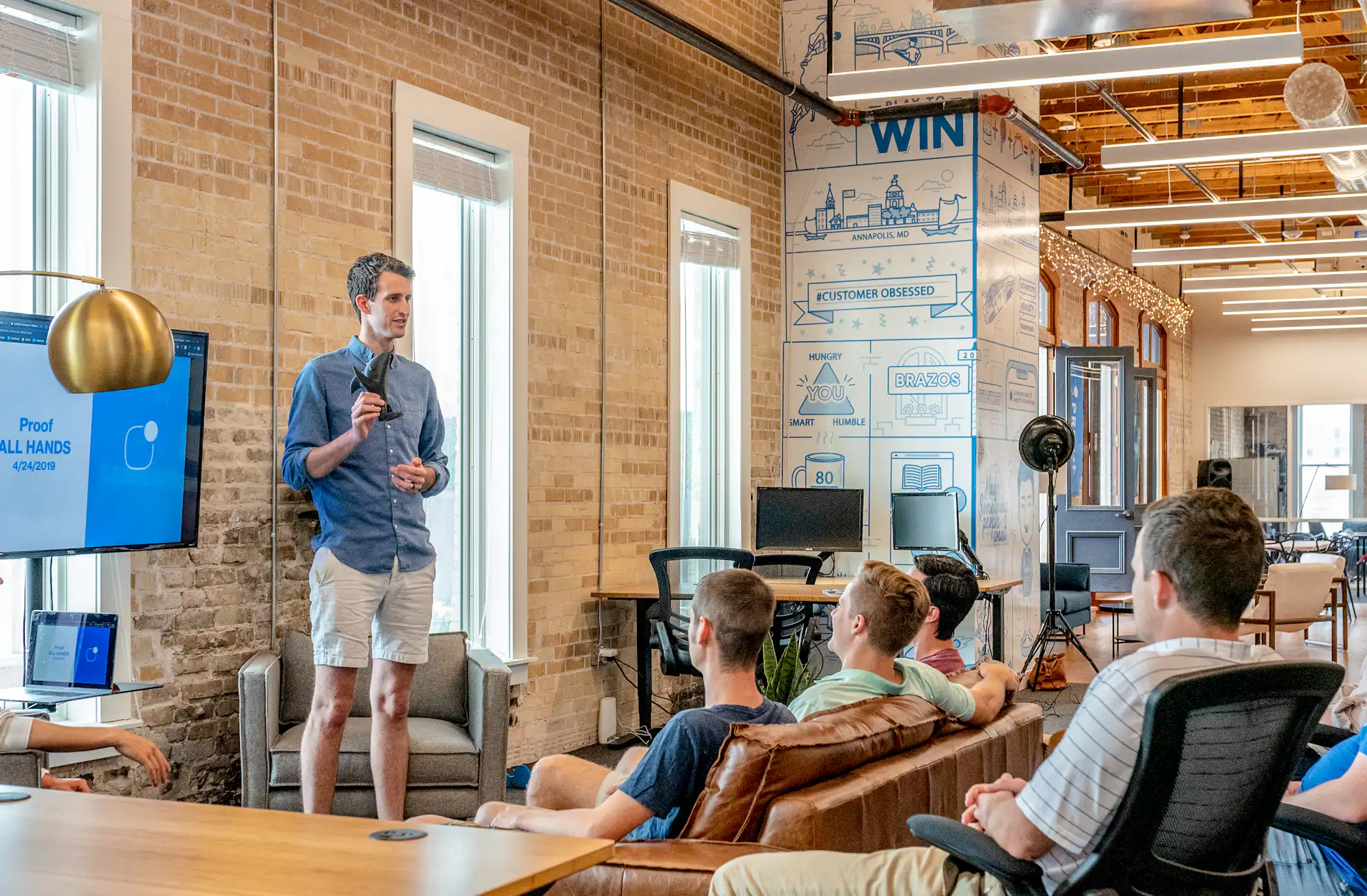 Manager presenting to a team in an open plan office