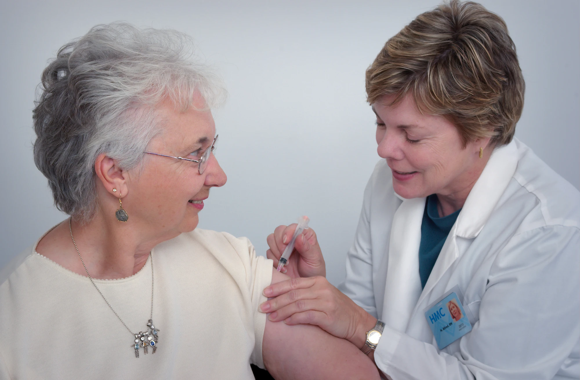 Nurse giving medication support to an older woman